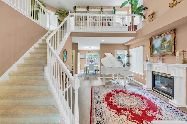 7 Marisa Dr, Middle Island, NY 11953 - stairs with wood finished floors, a high ceiling, a glass covered fireplace, and baseboards