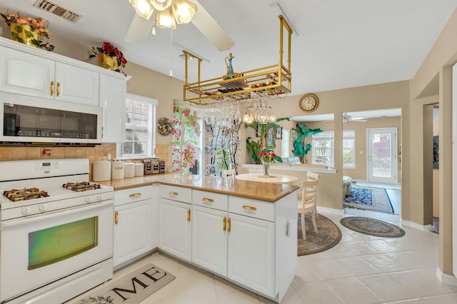 7 Marisa Dr, Middle Island, NY 11953 - kitchen featuring white appliances, a ceiling fan, a peninsula, white cabinetry, and plenty of natural light