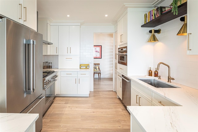 16 Rockledge Ave Unit 5D-2, Ossining, NY 10562 - kitchen featuring high quality appliances, a sink, open shelves, light wood-style floors, and light stone countertops