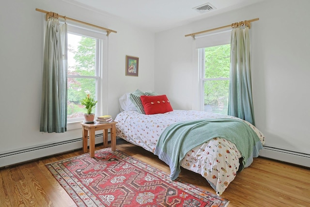2 Amber Ridge Rd, Chestnut Ridge, NY 10977 - bedroom with multiple windows, wood finished floors, and a baseboard heating unit
