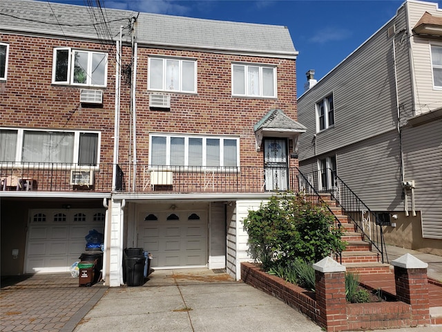 66-36 71st St, Middle Village, NY 11379 - view of front facade with concrete driveway, brick siding, an attached garage, and stairway