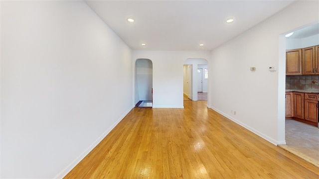 48-17 54th Ave, Maspeth, NY 11378 - spare room with arched walkways, baseboards, light wood-style floors, and recessed lighting