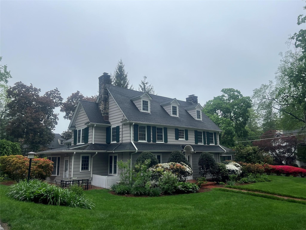 view of home's exterior with a chimney and a yard
