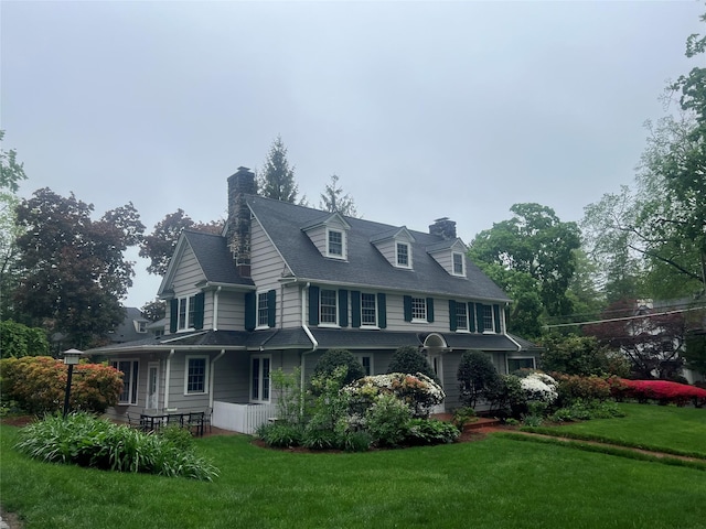 view of home's exterior with a chimney and a yard