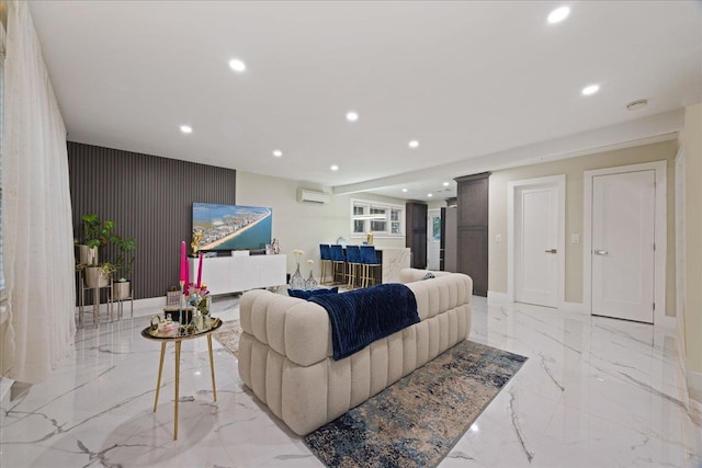living room with light marble finish floors, recessed lighting, a wall mounted air conditioner, an accent wall, and baseboards