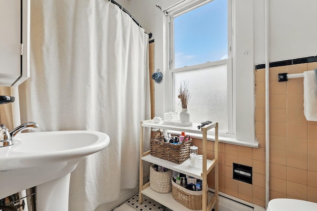 40 Longview Ave, White Plains, NY 10605 - bathroom featuring tile walls, toilet, a sink, a baseboard heating unit, and a shower with shower curtain