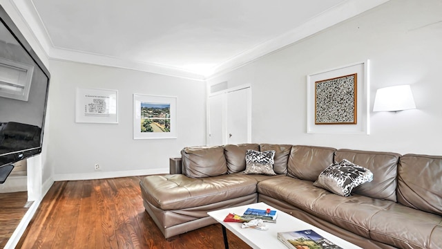 living room featuring wood finished floors, ornamental molding, and baseboards