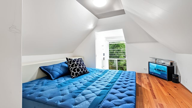 bedroom featuring wood finished floors and vaulted ceiling