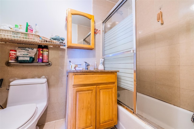 bathroom with toilet, vanity, and enclosed tub / shower combo