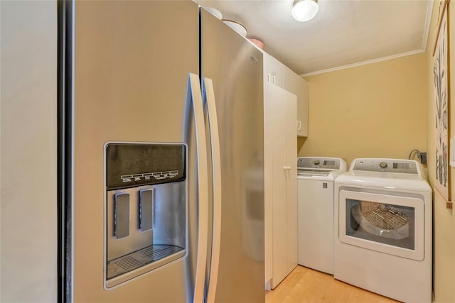 laundry area featuring washer and clothes dryer, light wood-style floors, and ornamental molding