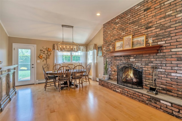dining room featuring a fireplace, wood finished floors, lofted ceiling, baseboards, and a baseboard radiator