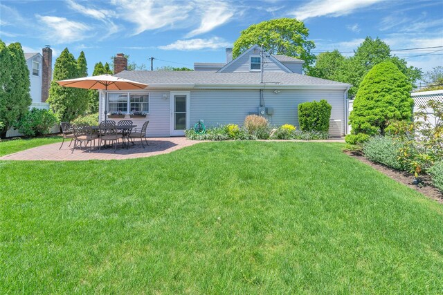 rear view of house featuring a patio area, a yard, and roof with shingles