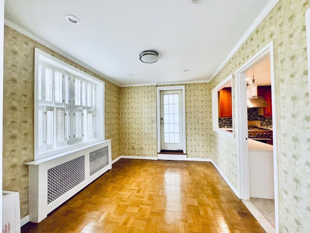 unfurnished room featuring radiator heating unit, crown molding, and baseboards