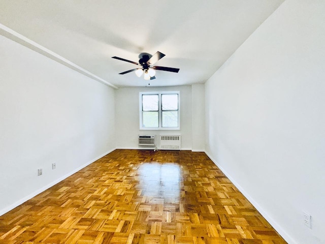 empty room featuring baseboards, radiator, and ceiling fan