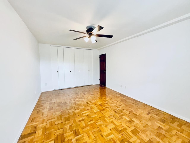 unfurnished bedroom with baseboards, a ceiling fan, and a closet