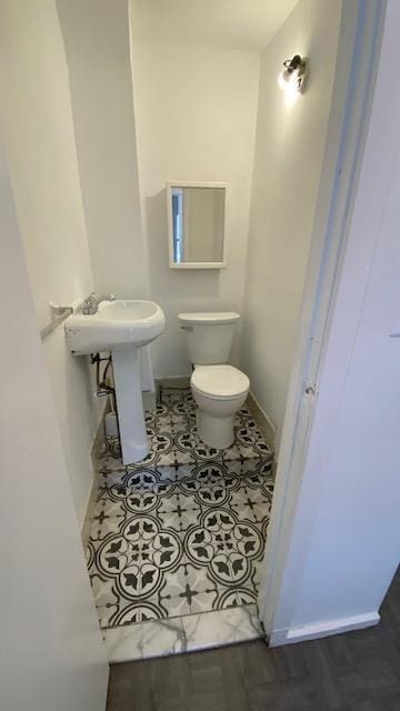 bathroom featuring toilet and baseboards