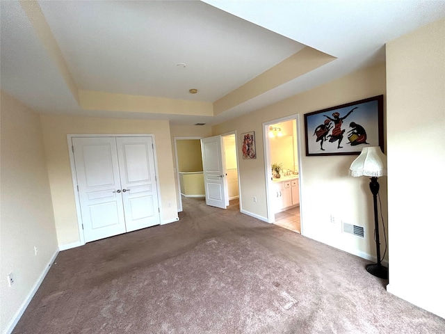 19 Brighton Dr Unit 1703, Newburgh, NY 12550 - unfurnished bedroom featuring a tray ceiling, carpet flooring, baseboards, and a closet