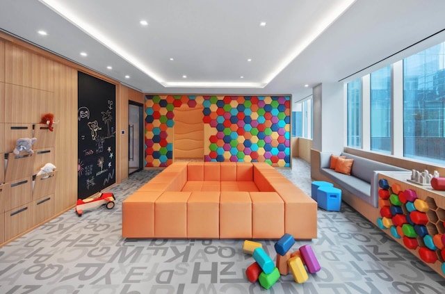 rec room featuring recessed lighting, light colored carpet, and a tray ceiling