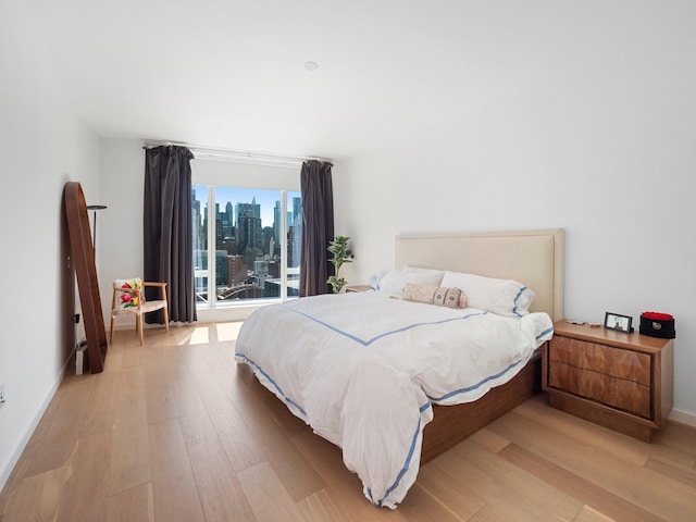 1 W End Ave Unit 26D, New York Manhattan, NY 10023 - bedroom featuring light wood-style flooring, access to exterior, baseboards, and a skyline view
