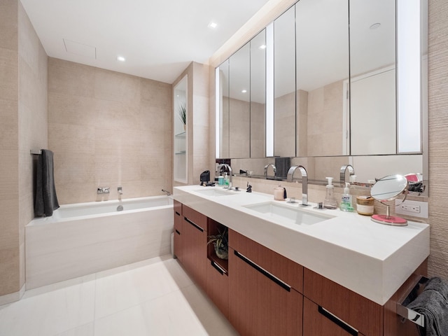 1 W End Ave Unit 26D, New York Manhattan, NY 10023 - bathroom featuring tile walls, double vanity, a bath, and tile patterned flooring