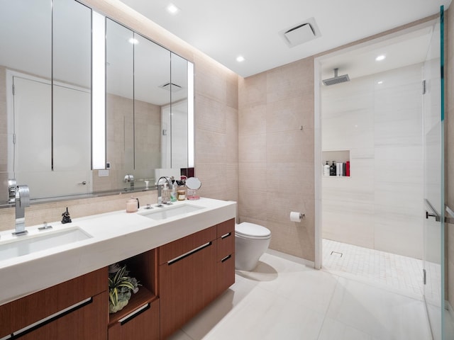 1 W End Ave Unit 26D, New York Manhattan, NY 10023 - bathroom featuring a walk in shower, double vanity, toilet, tile walls, and tile patterned floors