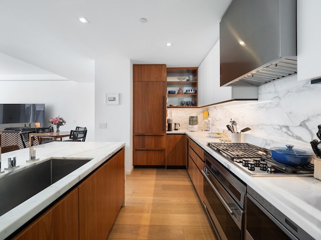 1 W End Ave Unit 26D, New York Manhattan, NY 10023 - kitchen featuring appliances with stainless steel finishes, wall chimney range hood, modern cabinets, brown cabinetry, and recessed lighting