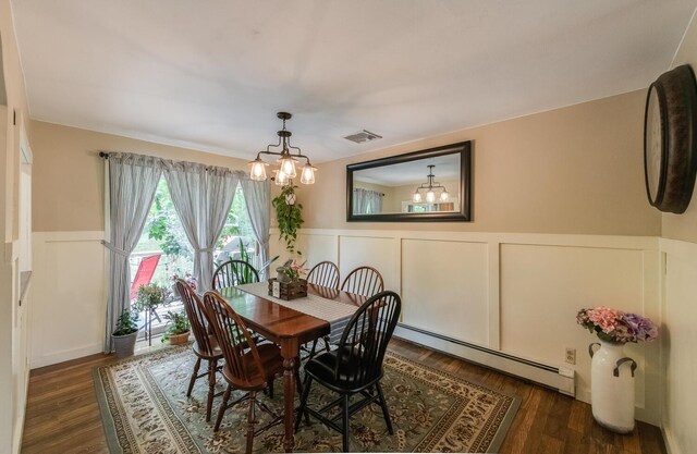 15 Marshall Dr, Poughkeepsie, NY 12601 - dining area with a chandelier, a baseboard heating unit, a decorative wall, wainscoting, and wood finished floors