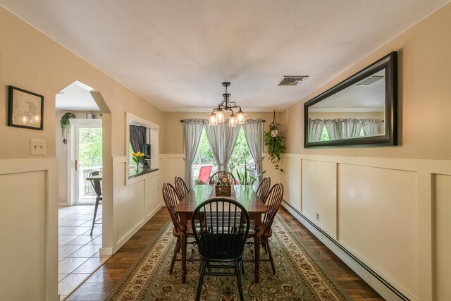 15 Marshall Dr, Poughkeepsie, NY 12601 - dining area featuring a baseboard radiator, a chandelier, arched walkways, wainscoting, and plenty of natural light