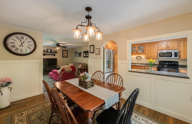 15 Marshall Dr, Poughkeepsie, NY 12601 - dining room featuring a ceiling fan, dark wood finished floors, arched walkways, and a wainscoted wall