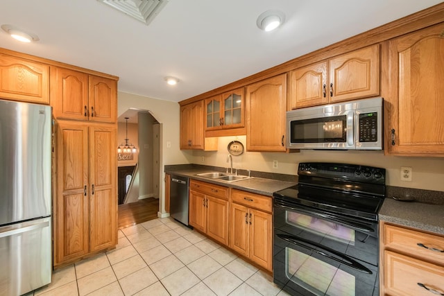 15 Marshall Dr, Poughkeepsie, NY 12601 - kitchen with appliances with stainless steel finishes, a sink, dark countertops, arched walkways, and light tile patterned flooring