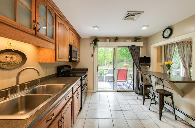 15 Marshall Dr, Poughkeepsie, NY 12601 - kitchen featuring stainless steel microwave, double oven range, a sink, dark countertops, and brown cabinets