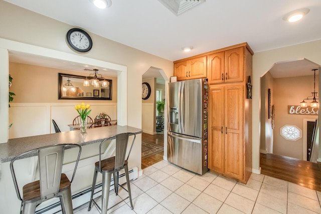15 Marshall Dr, Poughkeepsie, NY 12601 - kitchen featuring stainless steel refrigerator with ice dispenser, arched walkways, light tile patterned floors, and baseboard heating