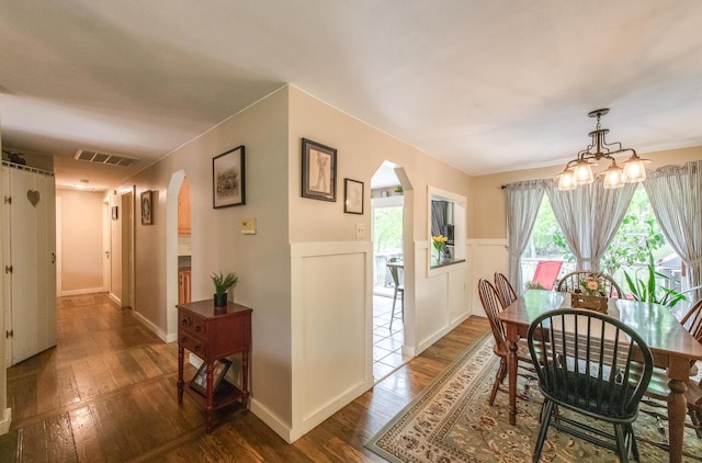 15 Marshall Dr, Poughkeepsie, NY 12601 - dining room featuring arched walkways, dark wood finished floors, a chandelier, and wainscoting