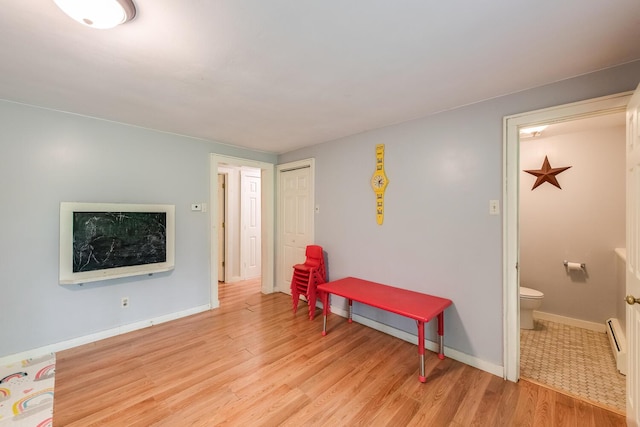 15 Marshall Dr, Poughkeepsie, NY 12601 - rec room featuring a baseboard radiator, light wood-style flooring, and baseboards