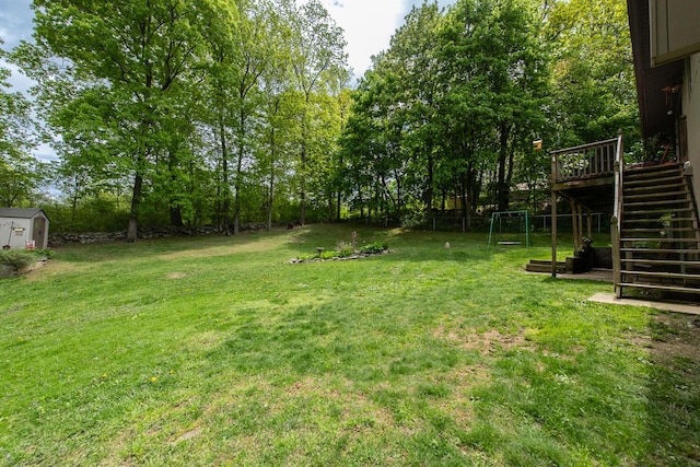 15 Marshall Dr, Poughkeepsie, NY 12601 - view of grassy yard featuring stairway, a deck, a shed, an outbuilding, and view of scattered trees
