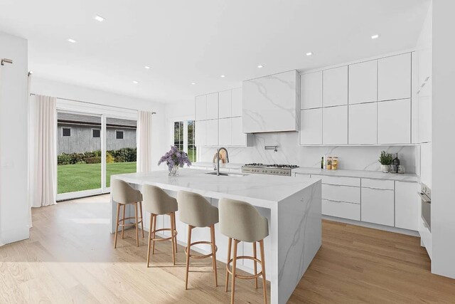 3 Dellaria Ave, Southampton, NY 11968 - kitchen featuring modern cabinets, a sink, a center island with sink, decorative backsplash, and recessed lighting