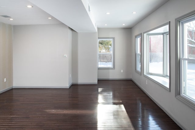 spare room featuring dark wood finished floors, baseboards, and recessed lighting
