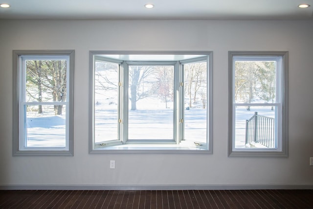 detailed view of wood finished floors, baseboards, and recessed lighting