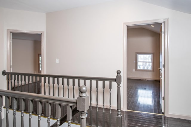 hall with an upstairs landing, wood finished floors, and baseboards