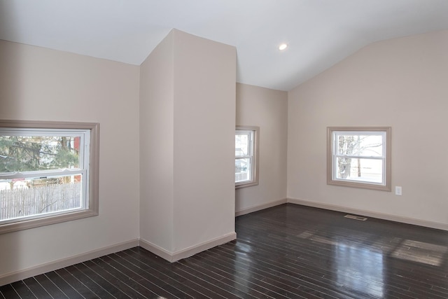 empty room with plenty of natural light, dark wood finished floors, lofted ceiling, baseboards, and recessed lighting
