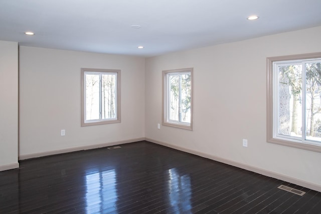 empty room featuring baseboards, dark wood-style floors, and recessed lighting