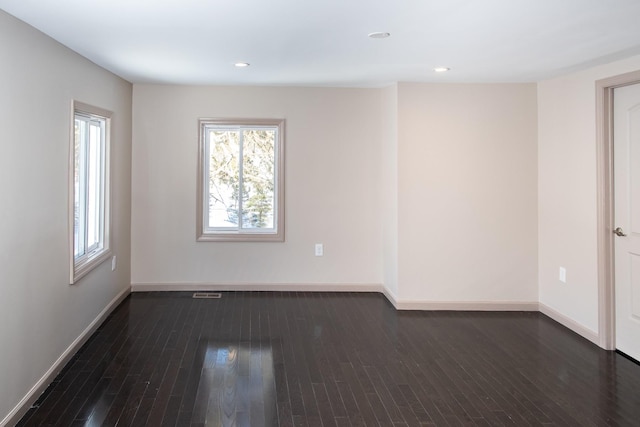 unfurnished room with healthy amount of natural light, baseboards, dark wood-type flooring, and recessed lighting