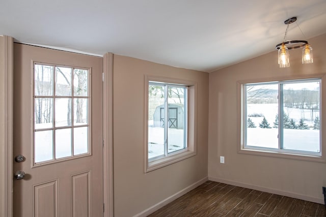 doorway to outside featuring lofted ceiling, dark wood finished floors, and baseboards