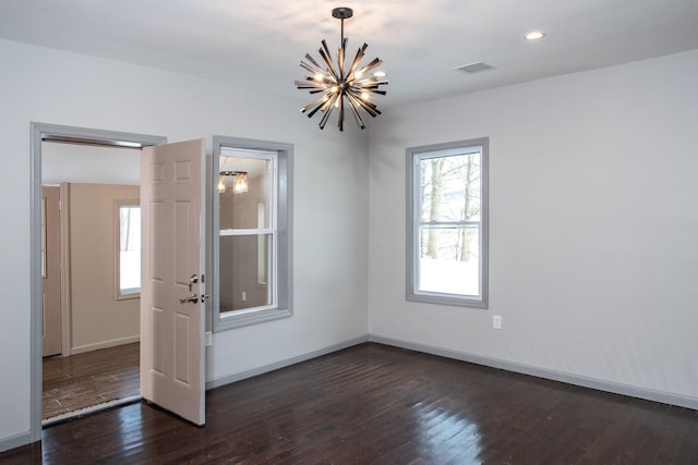 spare room featuring a chandelier, wood finished floors, baseboards, and recessed lighting