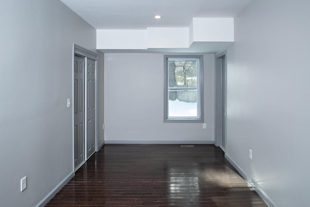 unfurnished room with wood finished floors, baseboards, and recessed lighting