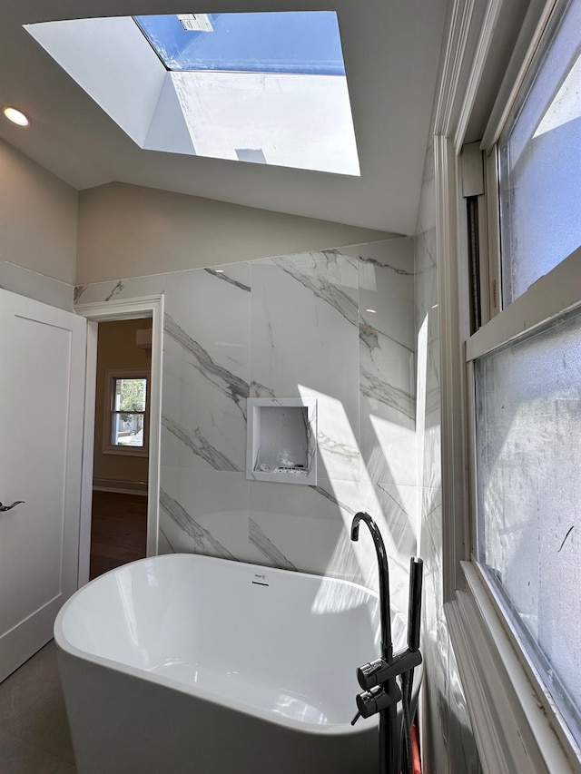 40 Allen St, New Hyde Park, NY 11040 - full bathroom featuring a freestanding bath, a skylight, vaulted ceiling, and recessed lighting
