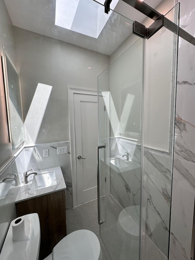 40 Allen St, New Hyde Park, NY 11040 - bathroom with toilet, a skylight, vanity, a marble finish shower, and tile walls