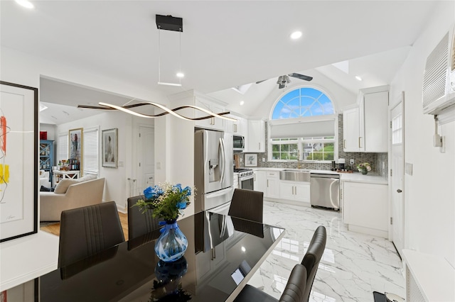 694 The Fenway, Baldwin, NY 11510 - dining space with vaulted ceiling, a ceiling fan, recessed lighting, and light marble finish floors