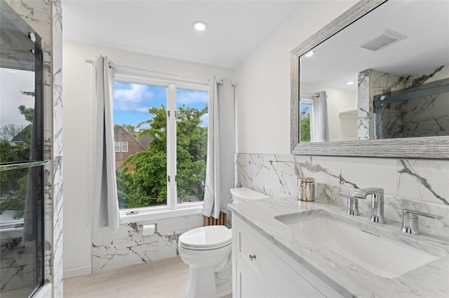 694 The Fenway, Baldwin, NY 11510 - full bath with healthy amount of natural light, toilet, a marble finish shower, vanity, and recessed lighting