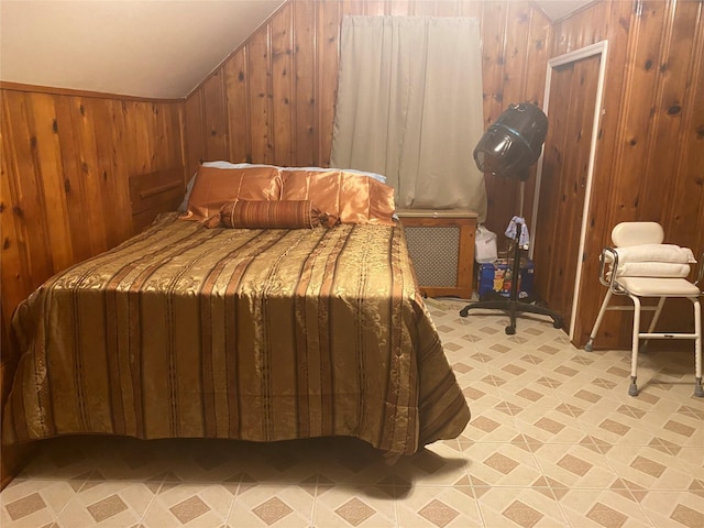 bedroom featuring wooden walls and vaulted ceiling